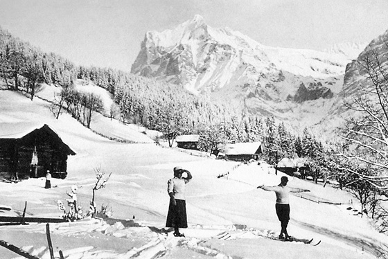 Balancierende Skifahrer auf dem Stein oberhalb Tuffbach. Bei einigen Skirennen gab es Stilnoten wie beim Schlittschuhlaufen. Im Hintergrund die Mittelmatta mit den Wohnhäusern der Familien Schlunegger und Lehrer Wyss.